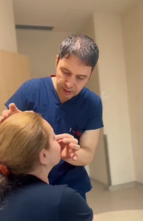 Doctor examining patient's nose during aesthetic check-up